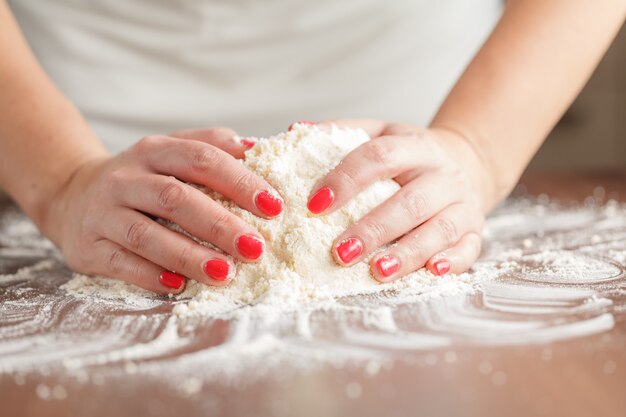 Produrre pasta cruda da mani femminili sul tavolo