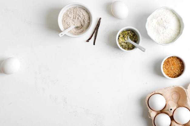 Produzione casalinga di pane fresco sano di altra pasticceria da ingredienti naturali su un tavolo grigio chiaro.