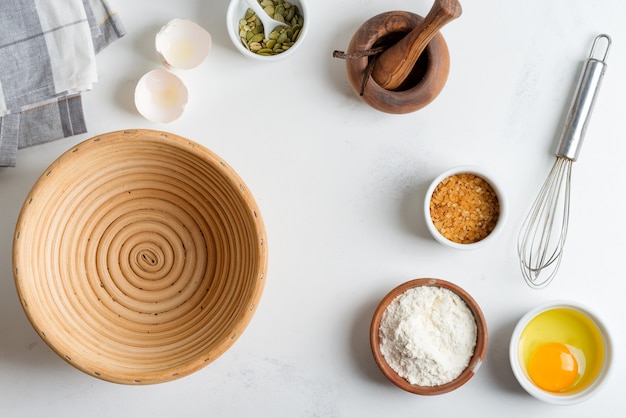 Produzione casalinga di pane fresco sano di altra pasticceria da ingredienti naturali su un tavolo grigio chiaro.