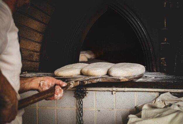 Produzione di pane cotto con forno a legna in un forno.