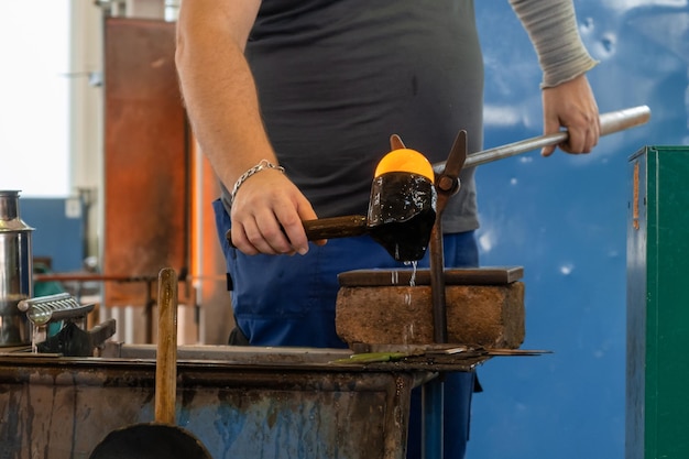 Produzione manuale del vetro mediante soffiatura del vetro da parte dell'operaio in fabbrica