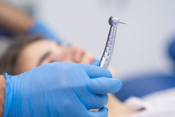 Professional dentistry services in clinic doctor in rubber gloves holding sterile dental drill
