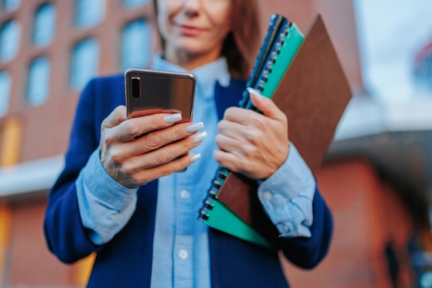 Professionista del centro una donna d'affari individualista tiene il suo telefono cellulare in mano