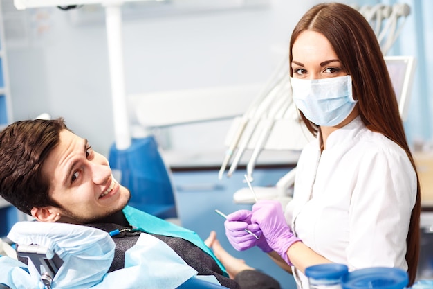 Professionista donna dentista medico che lavora Uomo alla clinica dentale uomo al dentista che si prende cura dei denti