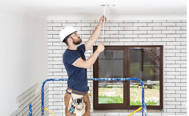 Professionista in tuta con strumenti sul sito di riparazione a figura intera. Concetto di ristrutturazione della casa.