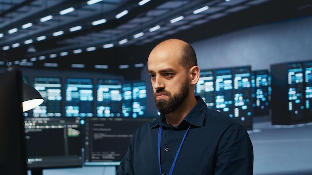 professionista IT che scrive codice sul PC per riparare i rack delle strutture di archiviazione dei dati