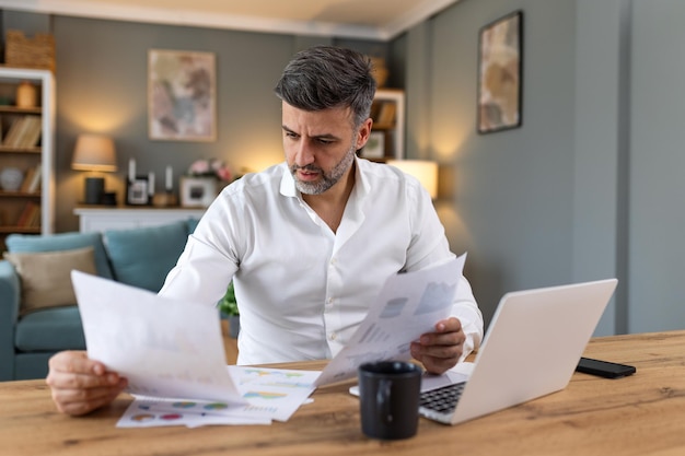 Professionisti aziendali Uomo d'affari che analizza i dati utilizzando il computer mentre trascorre del tempo in ufficio Giovane professionista sorridente in ufficio Grafici e grafici