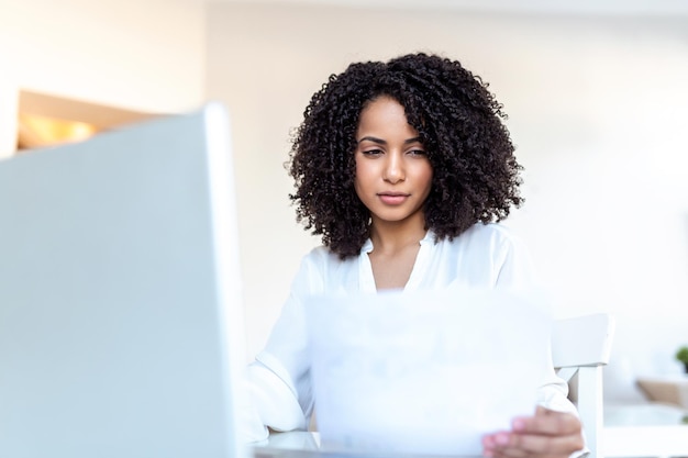 Professionisti d'affari Donna d'affari che analizza i dati utilizzando il computer mentre si trascorre del tempo in ufficio Bella giovane professionista sorridente Donna nera in ufficio Grafici e grafici