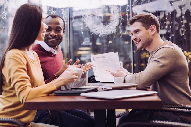 professionisti tre colleghi seduti al bar mentre si parla di business plan e sorridente