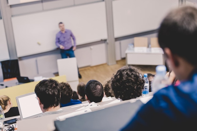 Professore che fa una presentazione nell'aula magna dell'università I partecipanti ascoltano la lezione e prendono appunti