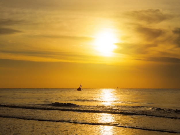 Profili i pescatori in una barca sul mare del tramonto