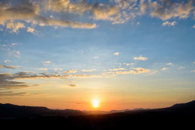 Profili il bellissimo paesaggio naturale del cielo colorato e delle montagne durante l'alba per lo sfondo