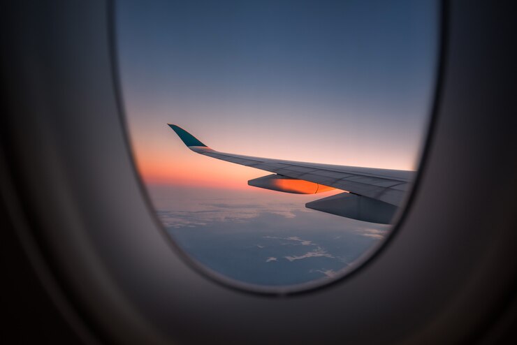 Foto profili l&#39;ala di un aeroplano alla vista dell&#39;alba attraverso la finestra.