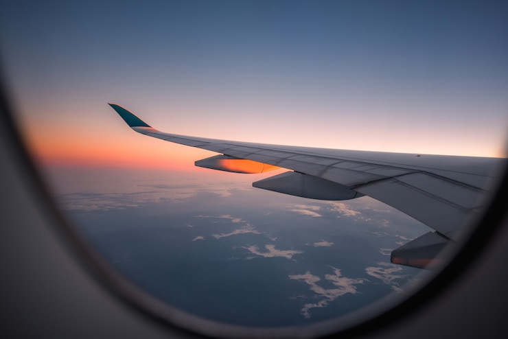 Foto profili l&#39;ala di un aeroplano alla vista dell&#39;alba attraverso la finestra.