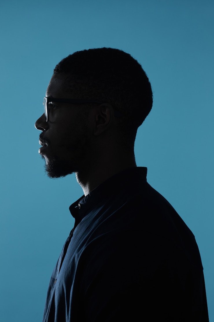 Foto profilo del profilo di vista laterale della silhouette maschile afroamericana su sfondo blu profondo