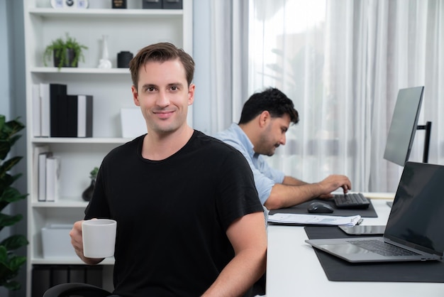 Profilo di un freelance sorridente che guarda la telecamera con una tazza di caffè Vendibile