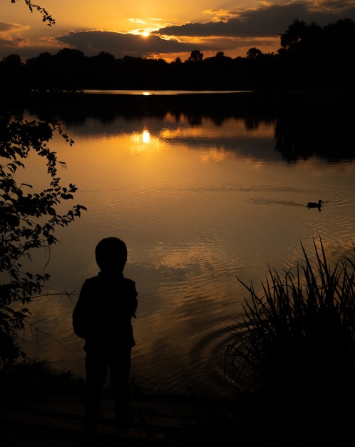 profilo di un ragazzo al tramonto sul lago