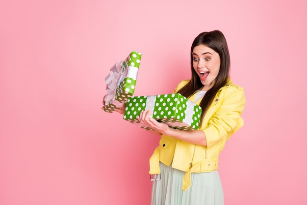 Profilo di una signora affascinante e divertente che si tiene per mano una grande scatola regalo verde