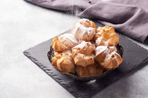 Profiteroles con crema pasticcera e zucchero a velo