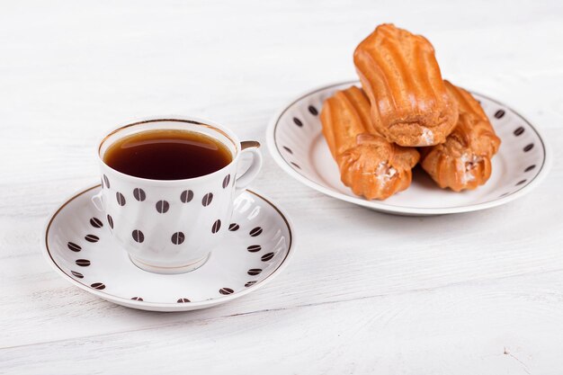 Profiteroles con crema sul tavolo con una tazza di caffè