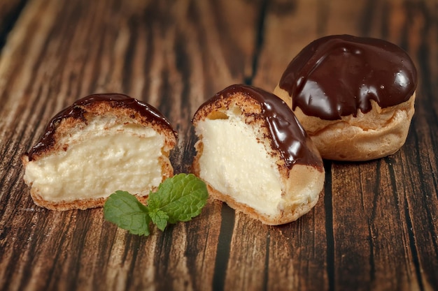 Profitroli di pasticceria fatta in casa con crema pasticcera su tavola di legno