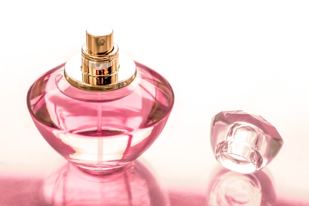 Profumeria spa e concetto di branding bottiglia di profumo rosa su sfondo lucido profumo floreale dolce profumo glamour e eau de parfum come regalo di festa e design di marca di cosmetici di bellezza di lusso