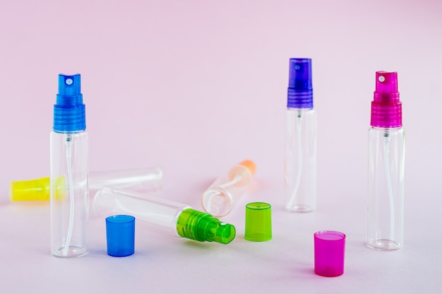 Profumo di vetro trasparente e bottiglia spray cosmetica su sfondo rosa per il concetto di imballaggio del prodotto