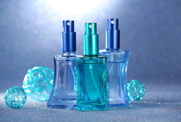 Profumo femminile in belle bottiglie su sfondo blu