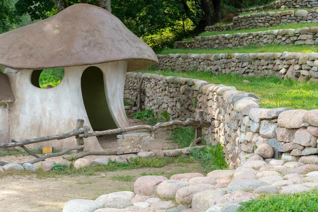 Progettazione del paesaggio Terrazza a gradini fissata con pietre grezze Villaggio Hobbit Casa di design a forma di grande fungo