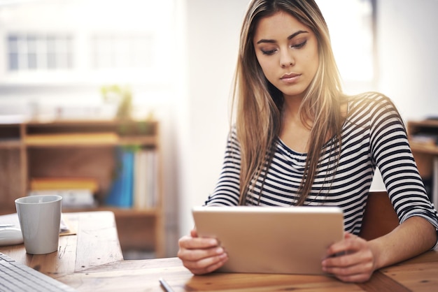 Progettazione di tablet e donna d'affari in ufficio che legge informazioni creative su Internet Ricerca sul caffè e designer professionista che lavora su progetti con la tecnologia digitale sul posto di lavoro