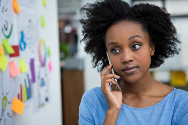 Progettista grafico femminile che parla sul telefono cellulare