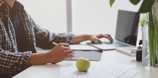 Progettista maschio che lavora al suo progetto mentre scrivendo sul computer portatile