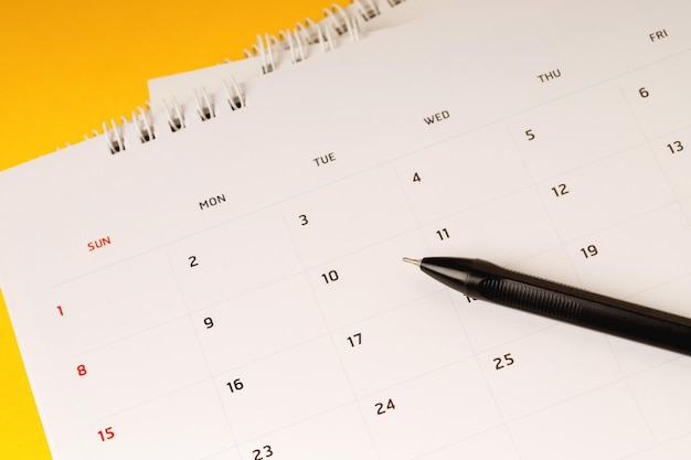 programma del mese di calendario per fissare riunioni su appuntamento o gestire l'orario ogni giorno e penna su sfondo giallo per pianificare il lavoro e il concetto di viaggio