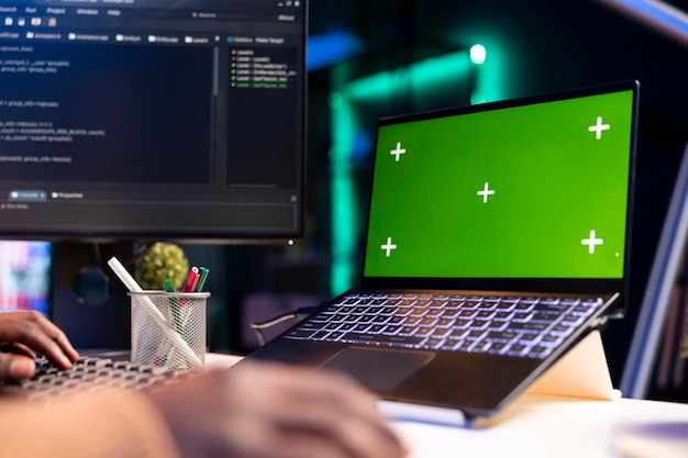 Programmatore afroamericano che lavora al cloud computing accanto allo schermo verde