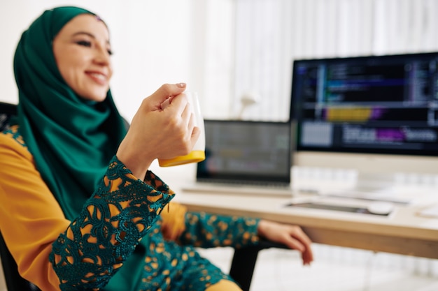 Programmatore femminile che beve caffè