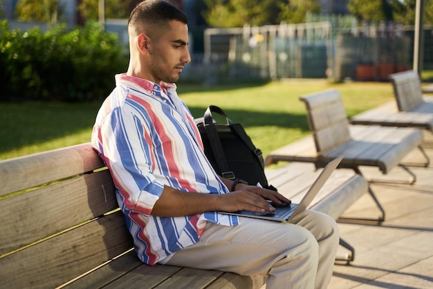 Programmatore mediorientale che utilizza un computer portatile che lavora a un progetto freelance online sul posto di lavoro