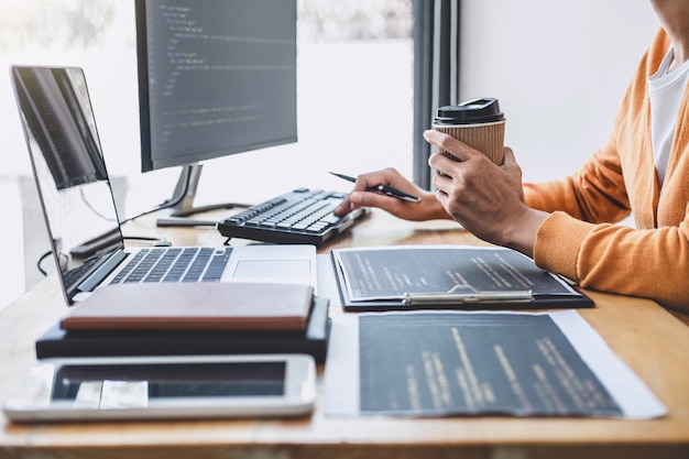 Programmer profesional muda yang bekerja mengembangkan pemrograman dan situs web yang bekerja di kantor perusahaan pengembang perangkat lunak, menulis kode dan mengetik kode data, Pemrograman dengan HTML, PHP, dan javascript