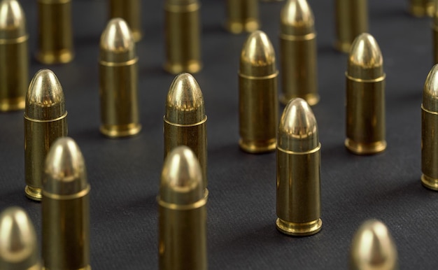 Proiettili di munizioni in ottone giallo sulla scrivania nera, disposti in piedi uno accanto all'altro