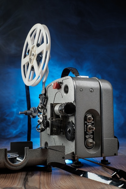 Proiettore cinematografico con il film sul pavimento di legno