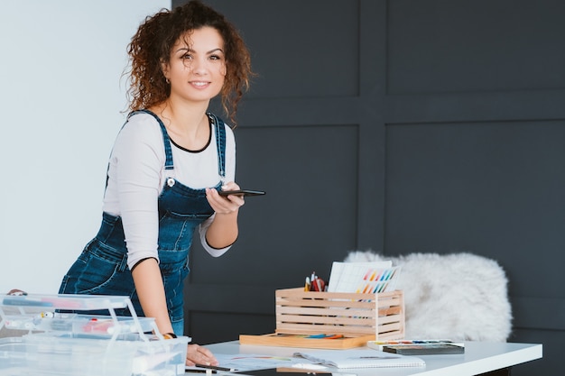 promozione sui social. artista femminile che utilizza la fotocamera dello smartphone per scattare una foto del suo nuovo dipinto