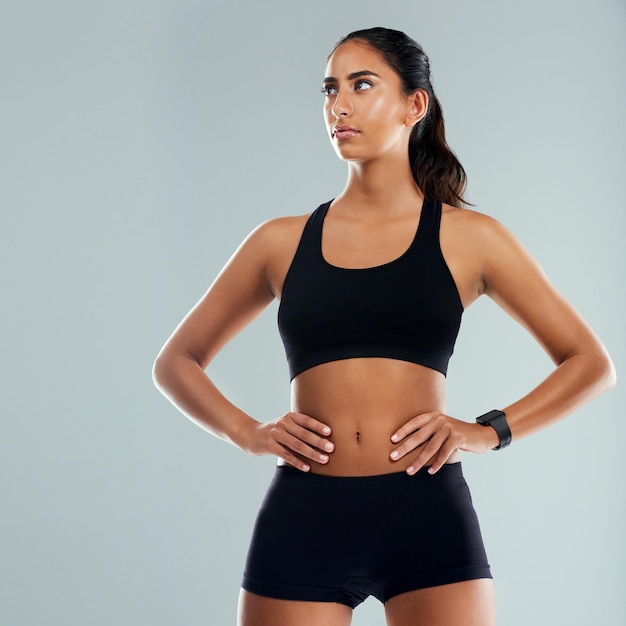 È pronta ad affrontare qualsiasi sfida Foto in studio di una giovane donna atletica che posa con le mani sui fianchi su uno sfondo grigio