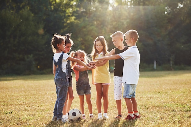 Pronti per la partita Giovani ragazzi sportivi con la palla da calcio stanno insieme nel campo in una giornata di sole