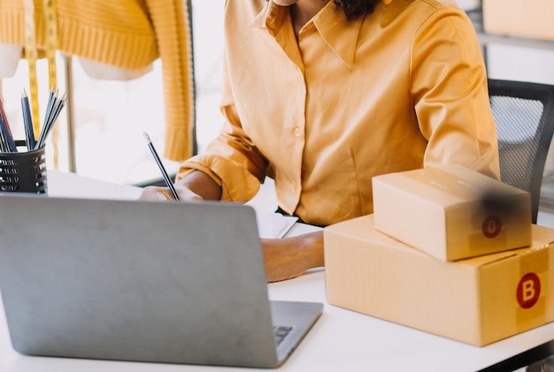 Proprietaria di un'azienda giovane donna asiatica stilista di moda che lavora sul suo designer nello showroom stile di vita stiloso sarto che prende misure su manichini per tagliare tessuti in studio Piccola impresa