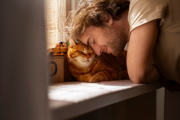 Proprietario con un gatto carino a casa