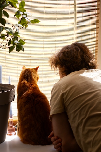 Proprietario con un gatto carino a casa