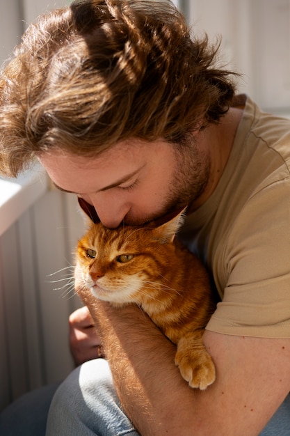 Proprietario con un gatto carino a casa