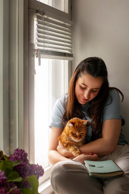 Proprietario con un gatto carino a casa