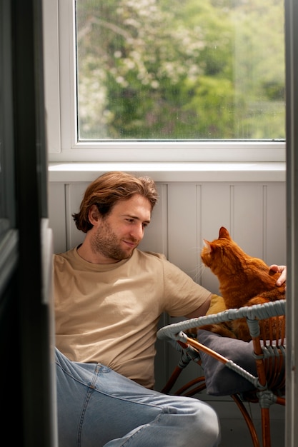Proprietario con un gatto carino a casa