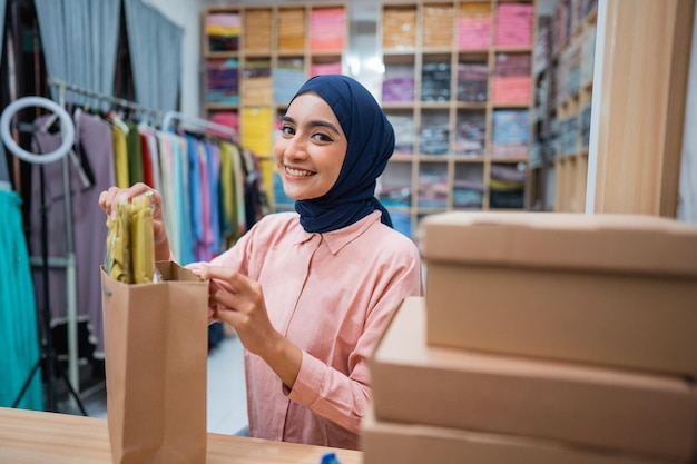 Proprietario della donna musulmana che controlla il prodotto prima della spedizione