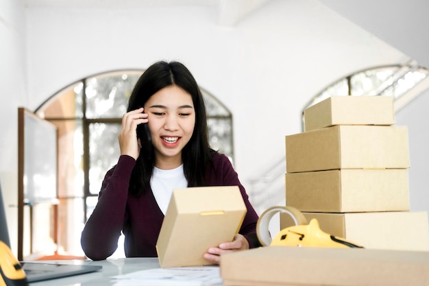 Proprietario di un negozio di affari online femminile che parla con il cliente utilizzando lo smartphone